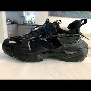 Black mens athletic shoe worn once by luxury fitness trainer for photo shoot.